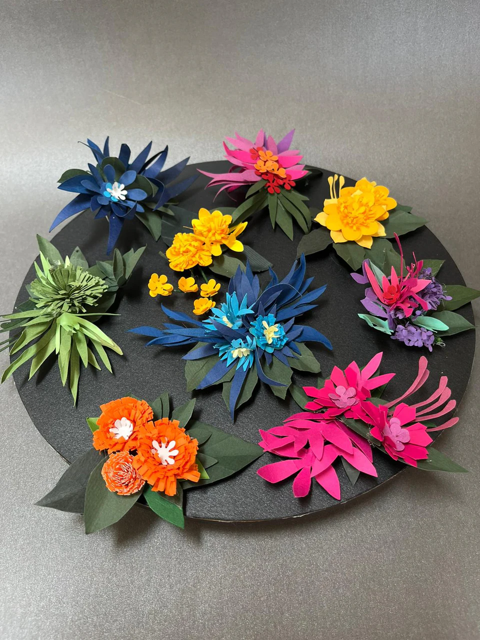 Paper flowers in blue, pink, yellow and orange scattered across a wide brim